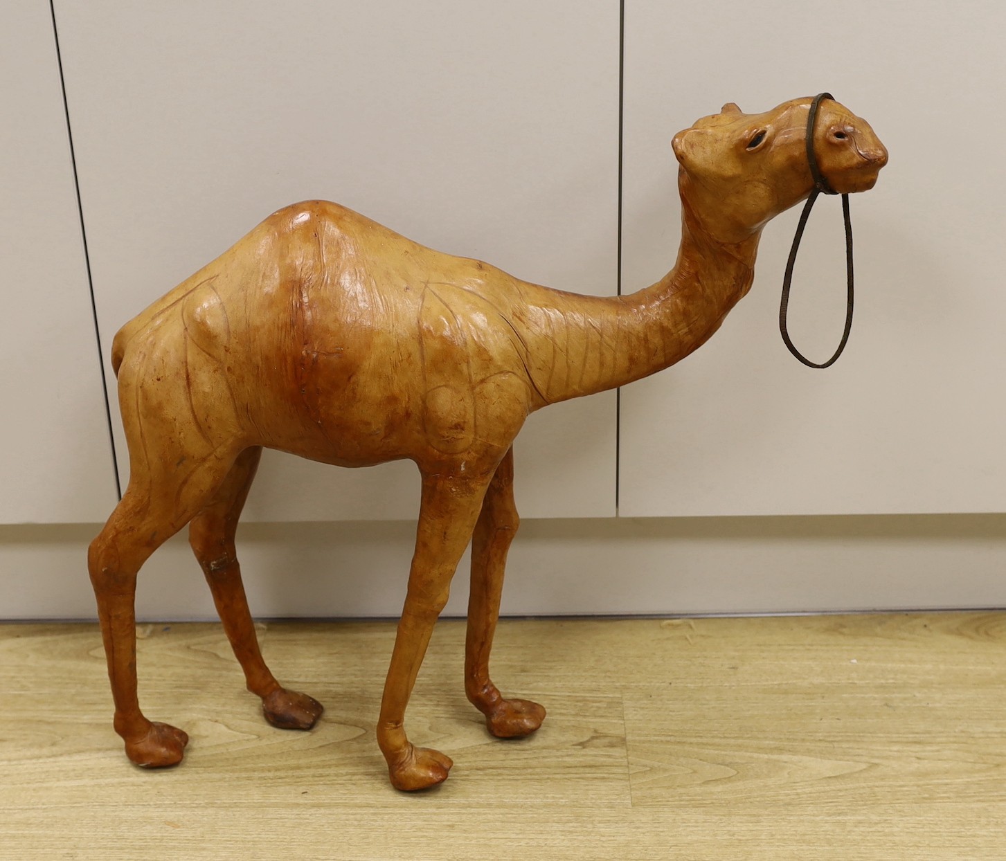 A Liberty style leather bound model of a camel, 64.5cm